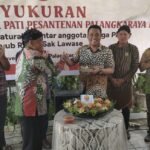 Ketua Kerukunan Warga Pati Pasantenan (KWPP) Kota Palangka Raya, Rosidi ketika memberikan potongan tumpeng kepada wakil Wali Kota Palangka Raya Achmad Zaini di acara ulang tahun ke-27, pada Sabtu (22/11).