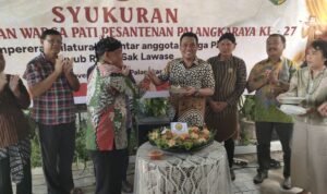 Ketua Kerukunan Warga Pati Pasantenan (KWPP) Kota Palangka Raya, Rosidi ketika memberikan potongan tumpeng kepada wakil Wali Kota Palangka Raya Achmad Zaini di acara ulang tahun ke-27, pada Sabtu (22/11).