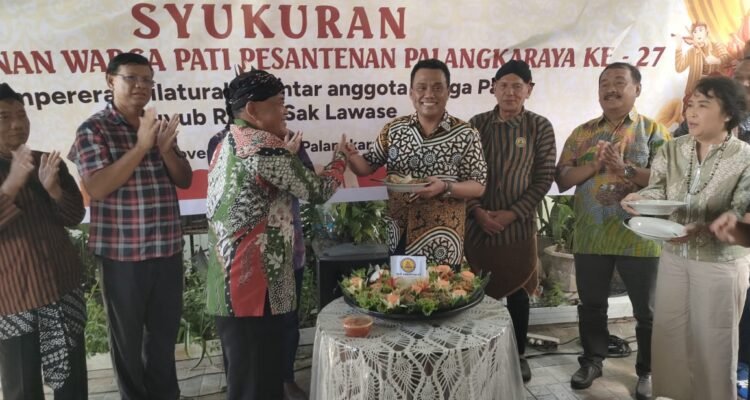 Ketua Kerukunan Warga Pati Pasantenan (KWPP) Kota Palangka Raya, Rosidi ketika memberikan potongan tumpeng kepada wakil Wali Kota Palangka Raya Achmad Zaini di acara ulang tahun ke-27, pada Sabtu (22/11).