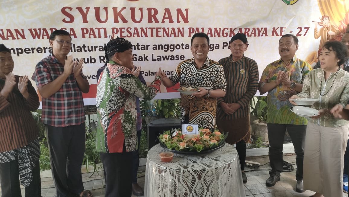 Ketua Kerukunan Warga Pati Pasantenan (KWPP) Kota Palangka Raya, Rosidi ketika memberikan potongan tumpeng kepada wakil Wali Kota Palangka Raya Achmad Zaini di acara ulang tahun ke-27, pada Sabtu (22/11).