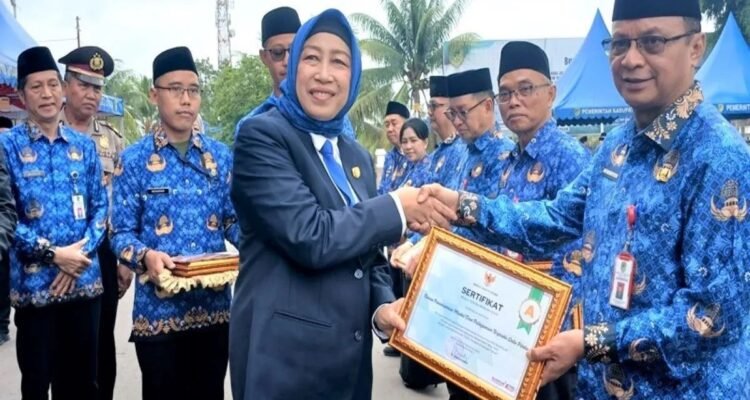 Ketua DPRD Barito Utara Mery Rukaini menyerahkan piagam penghargaan Indeks BerAKHLAK tertinggi dalam Survei Budaya Kerja dan Evaluasi Implementasi BerAKHLAK Tahun 2025, Senin (1/12).